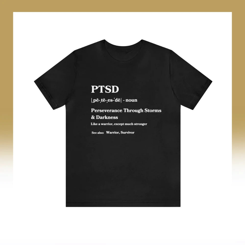 A black t-shirt adorned with inspirational quotes, offering a motivational reinterpretation of the acronym PTSD, which stands for "Perseverance Through Storms & Darkness," presented as a dictionary entry.