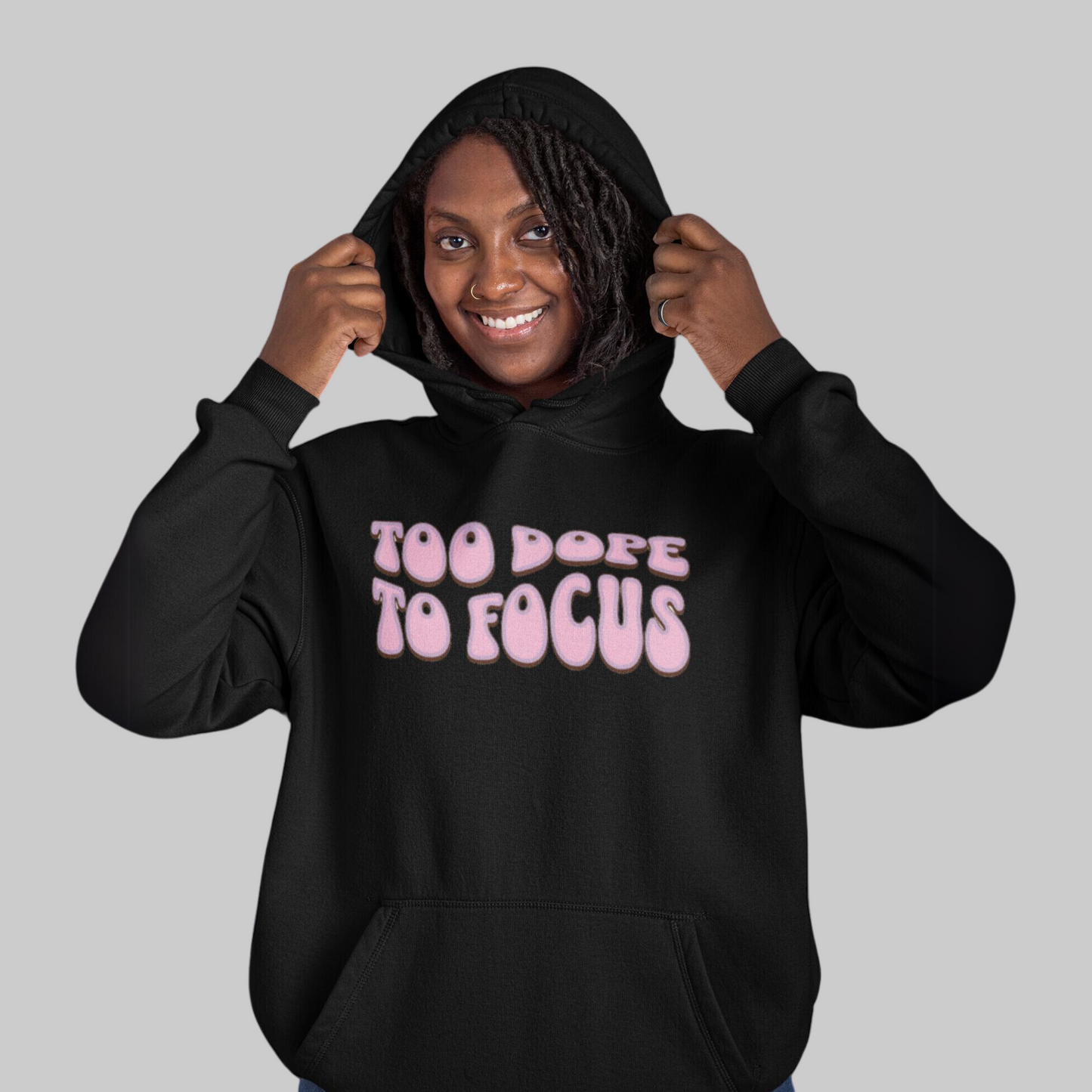 A smiling woman in a Too Dope To Focus Unisex Hooded Sweatshirt with the text "too dope to focus on mental health" printed on the front.